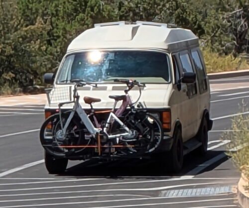 Stan the Tan Van that Can, a tan 90s Dodge van with bicycles on the front