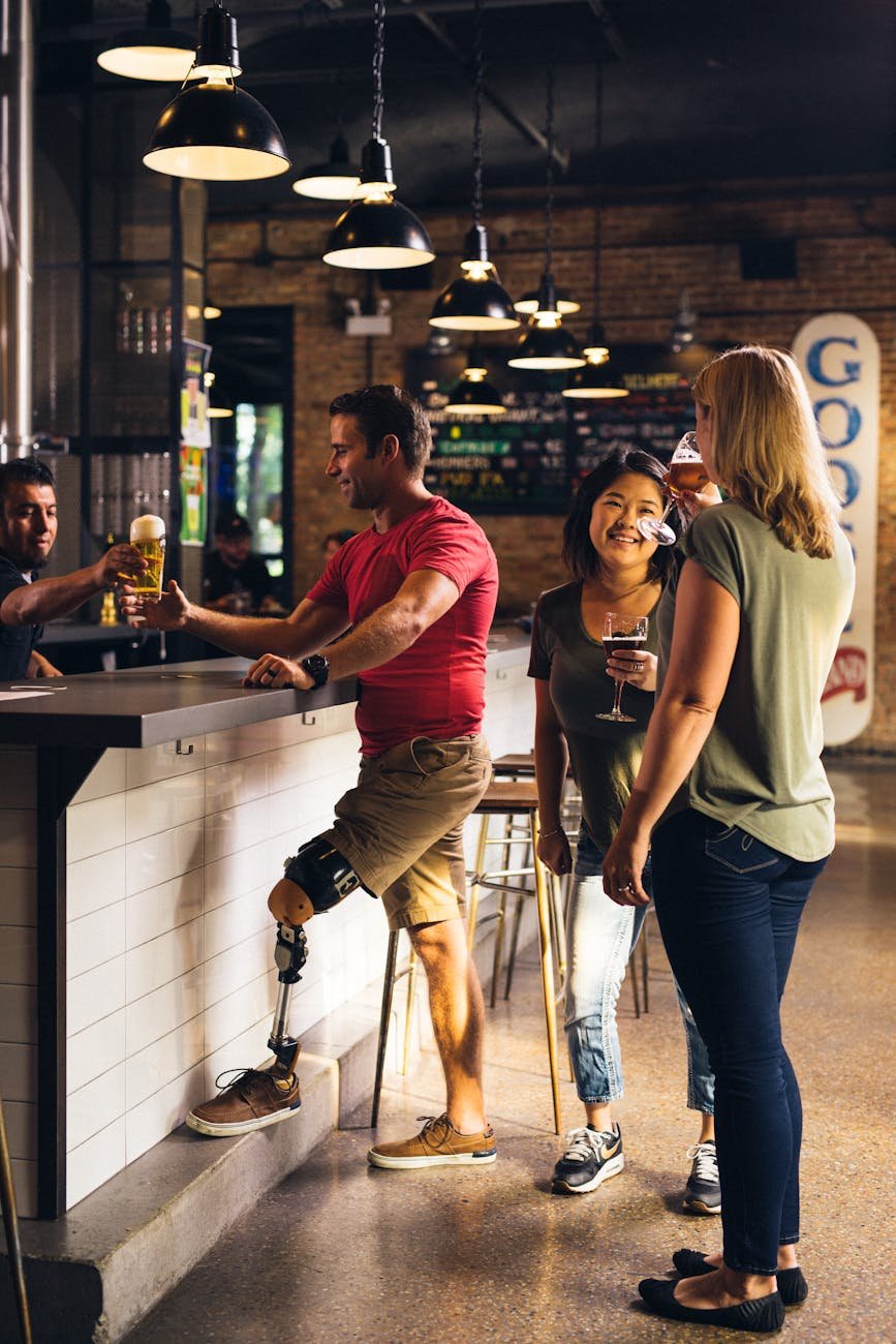 man being served beer next to two conversing women